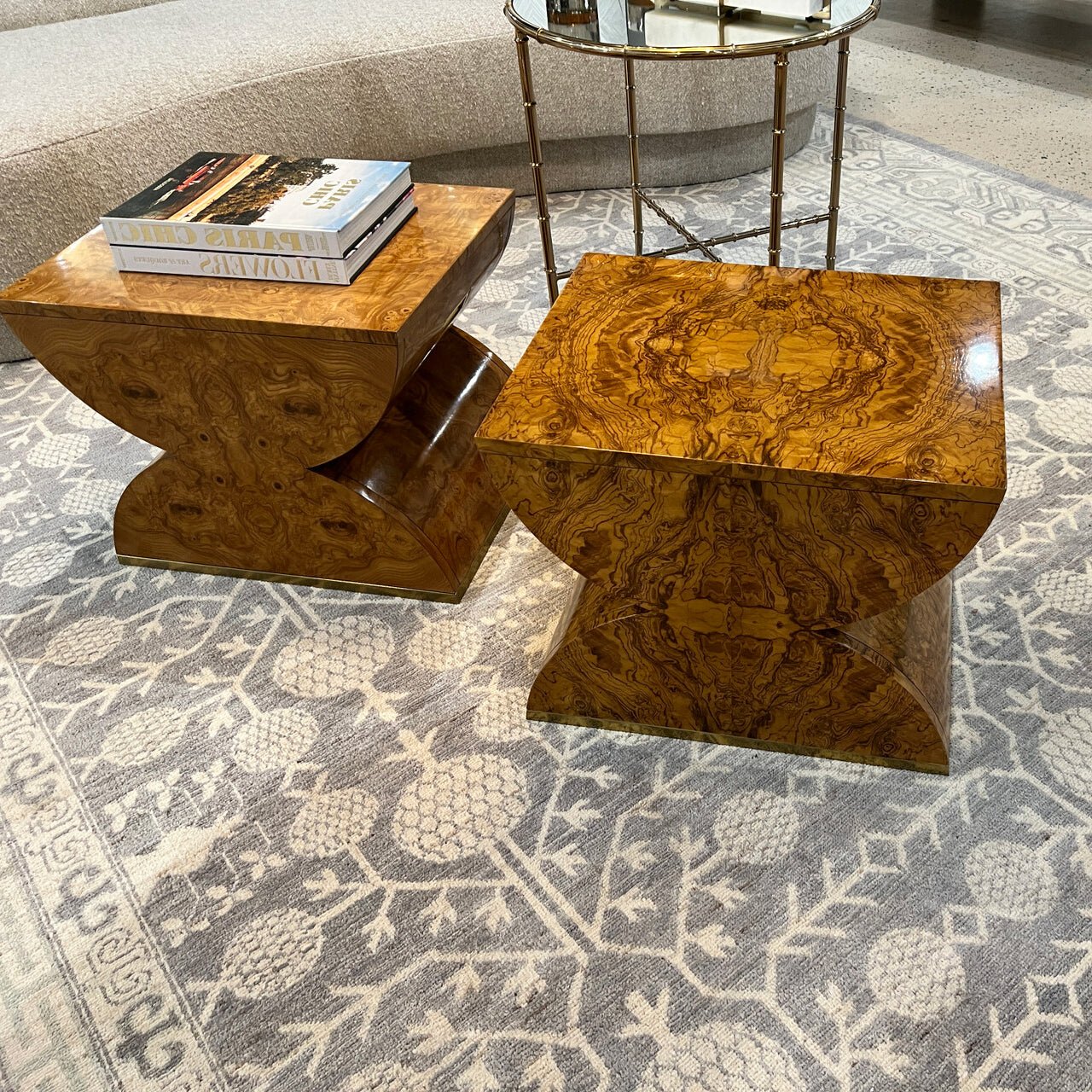 Two Olive Ash Burl wood accent tables on rug.