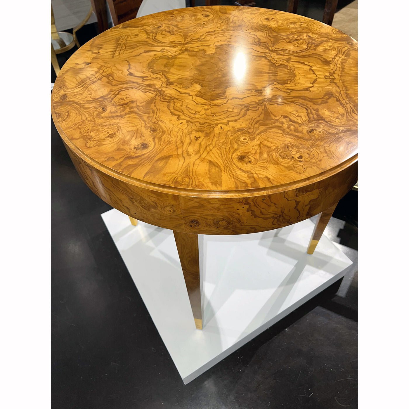Close-up of round olive wood side table surface.