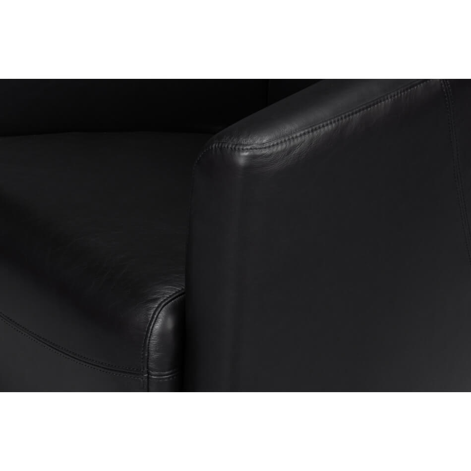 Black leather club chair, close-up armrest detail.