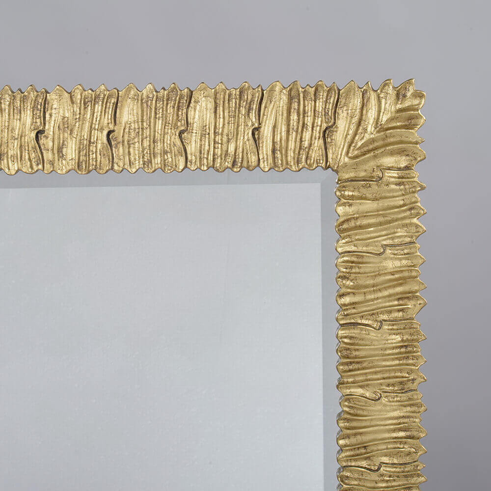 Detailed view of decorative gold frame corner on mirror.