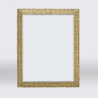 Gold-framed mirror on light background, front view.