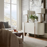 Media cabinet in living room setting with decor and lamps.