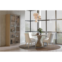 Oak pedestal table in minimalist dining area.