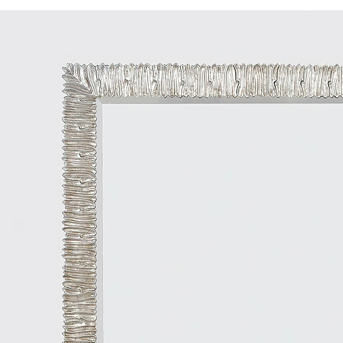 Detailed corner view of silver framed mirror.