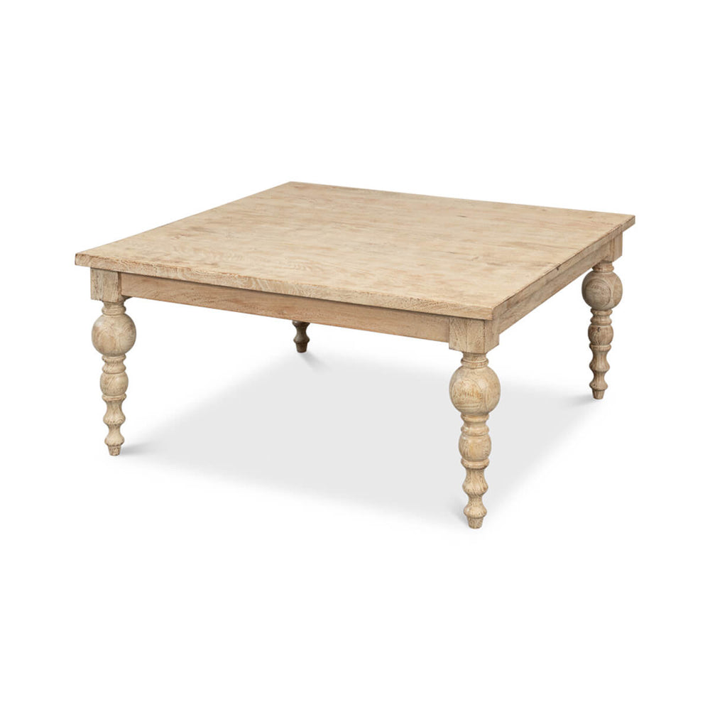 Square wood coffee table with ornate legs, angled view.