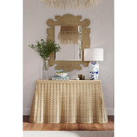 Raffia mirror above table in stylish living room.