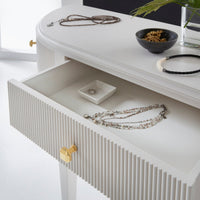 Upper drawer of console vanity with jewelry and decor.
