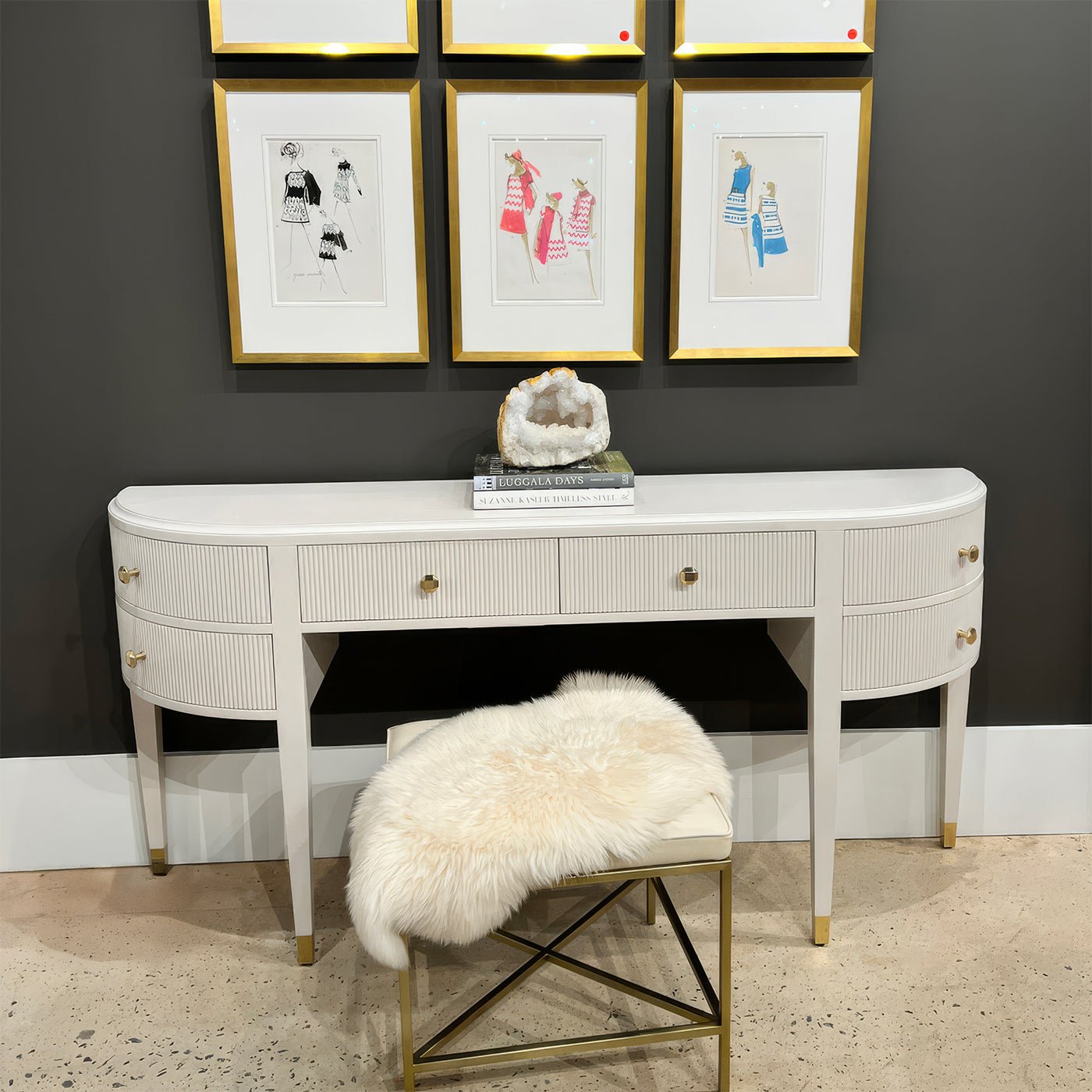 Console vanity with decorative items and upholstered bench.