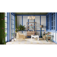 Coffee table styled in colorful room with wicker chairs.