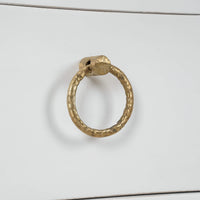 Gold handle detail on white nightstand drawer.