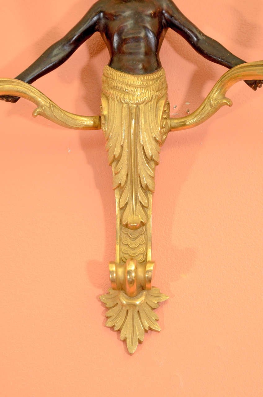 Detail of bronze sconce's ornate lower design.