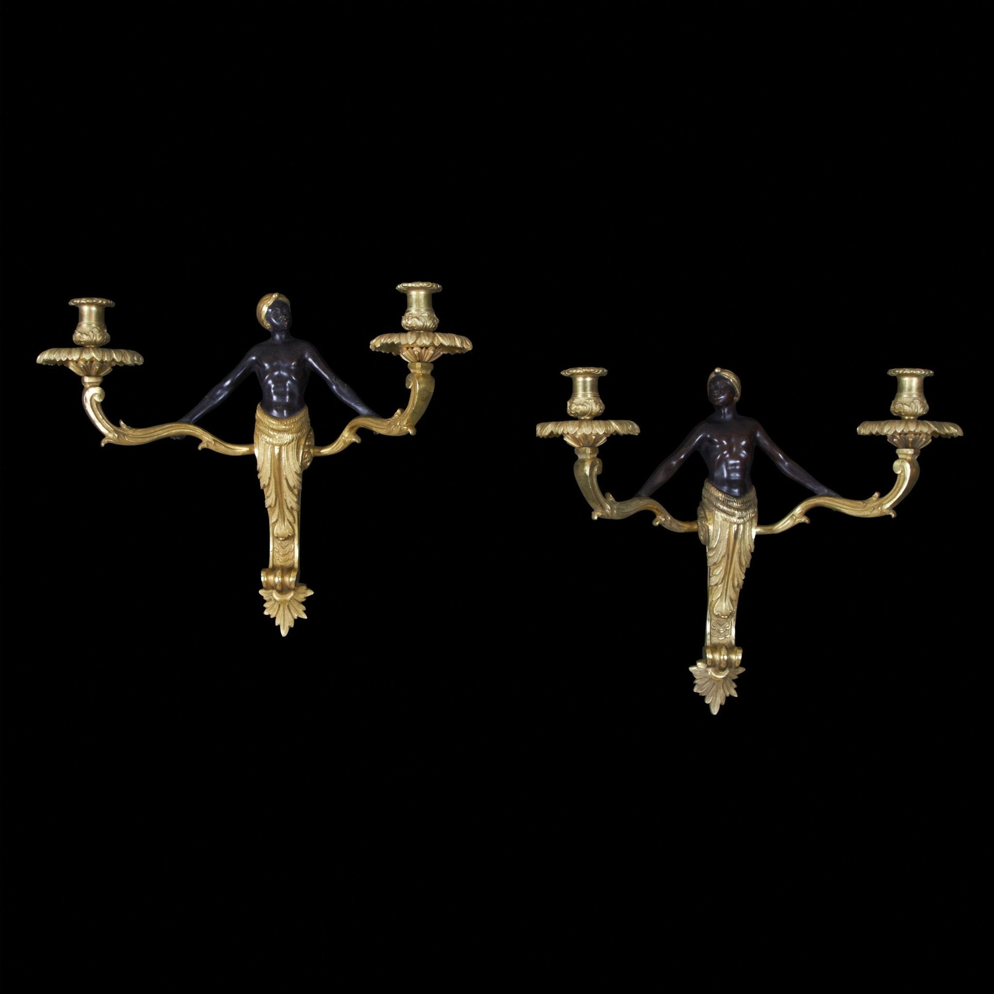 Louis XV bronze sconces on black background.