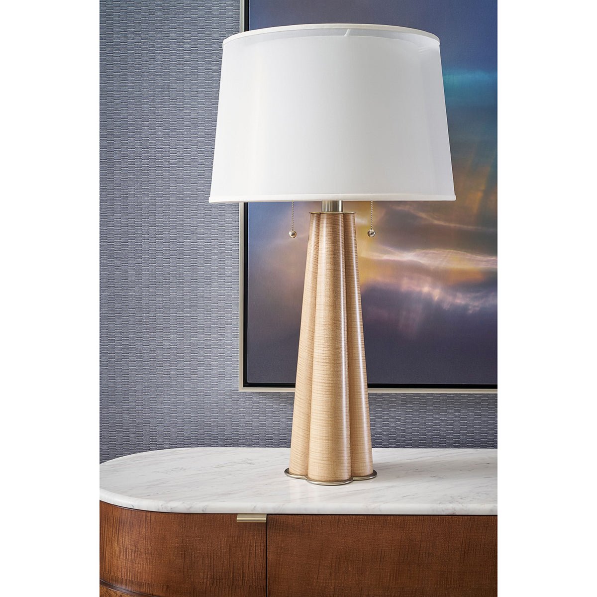 Art Deco table lamp on marble console with artwork.