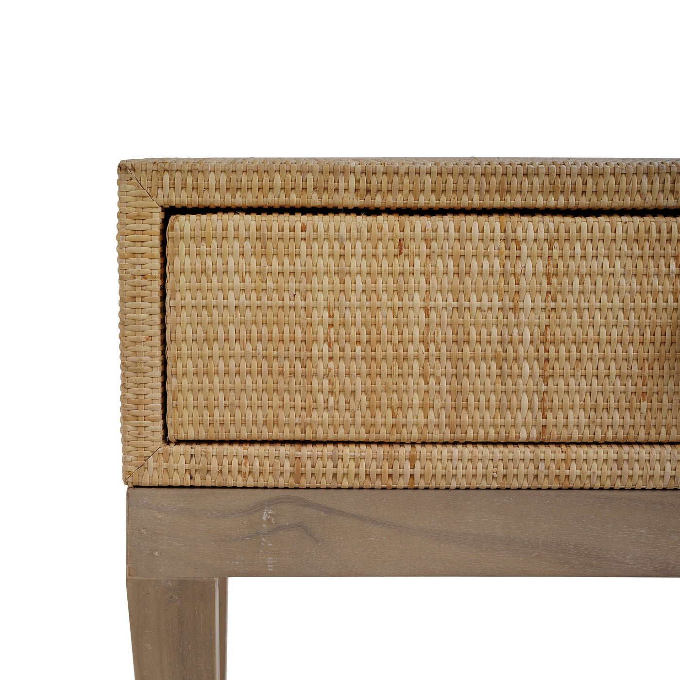 Close-up of nightstand drawer corner, rattan texture.