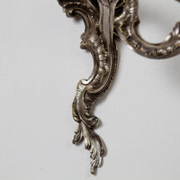 Base detail of graceful French Chinoiserie sconce, scrollwork.