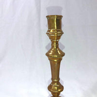 Close-up of a single bronze candlestick's upper section.