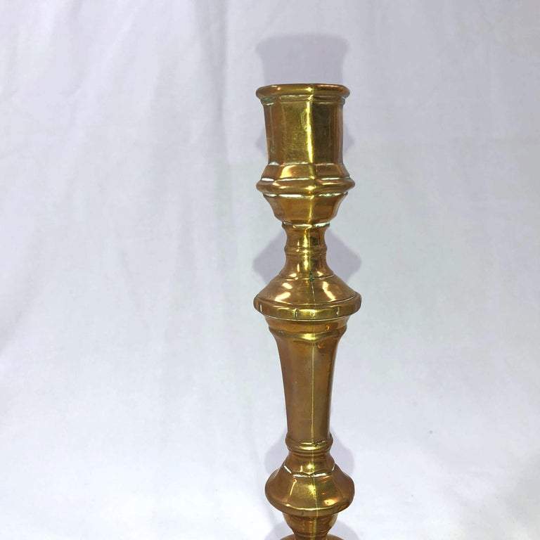 Close-up of a single bronze candlestick's upper section.