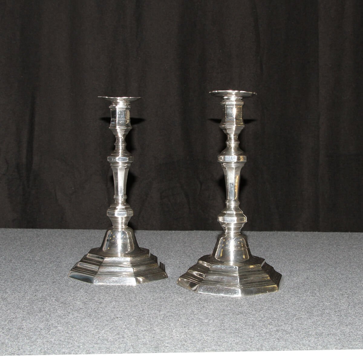 French candlesticks, front view, dark backdrop.