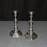 French Louis XVI candlesticks on dark background, side view.
