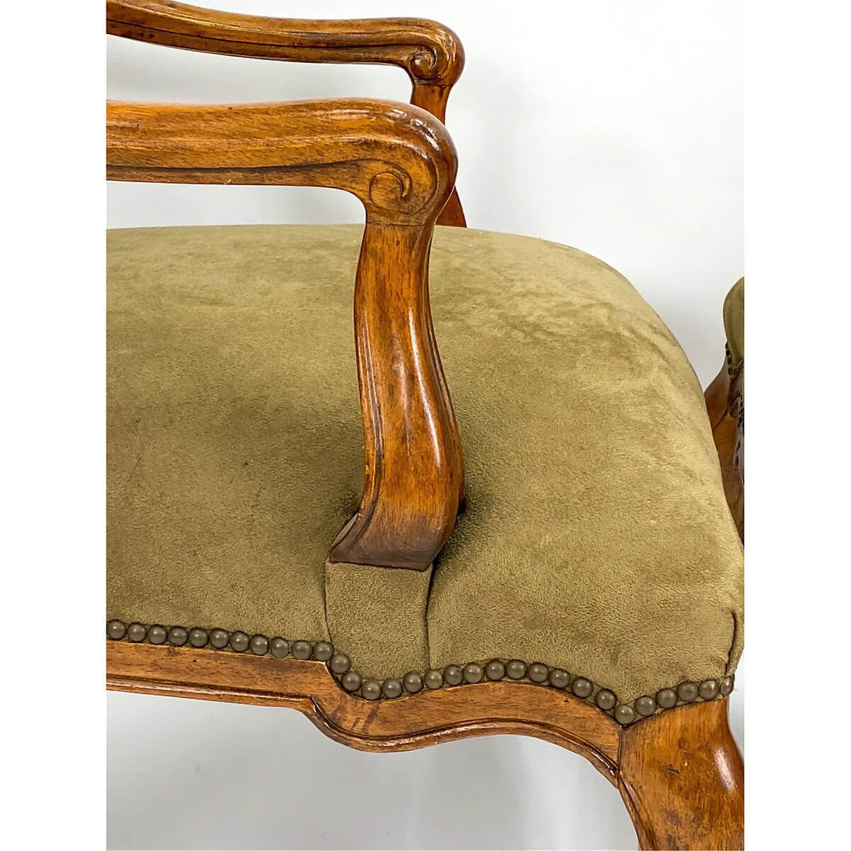 Detailed view of armchair armrest and upholstery.
