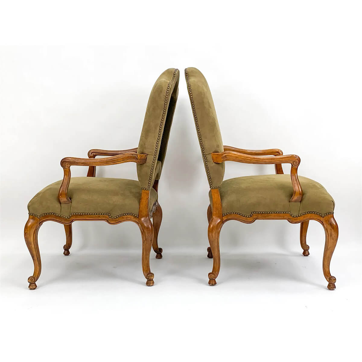 Back-to-back side view of antique armchairs.