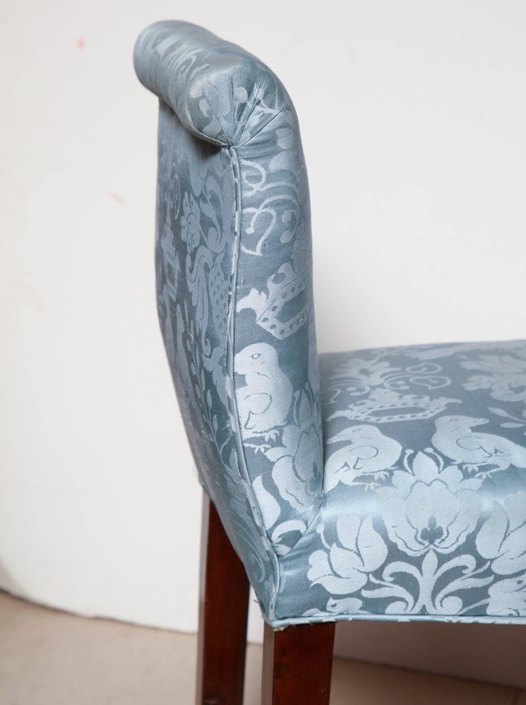 Upholstery detail with floral pattern on bench armrest.
