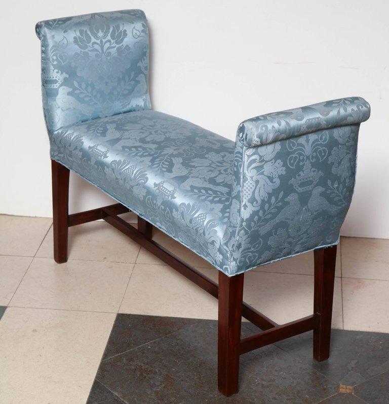 Angled backside view of blue upholstered mahogany bench.