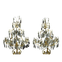 Pair of Louis XIV girandoles, lit background, intricate design