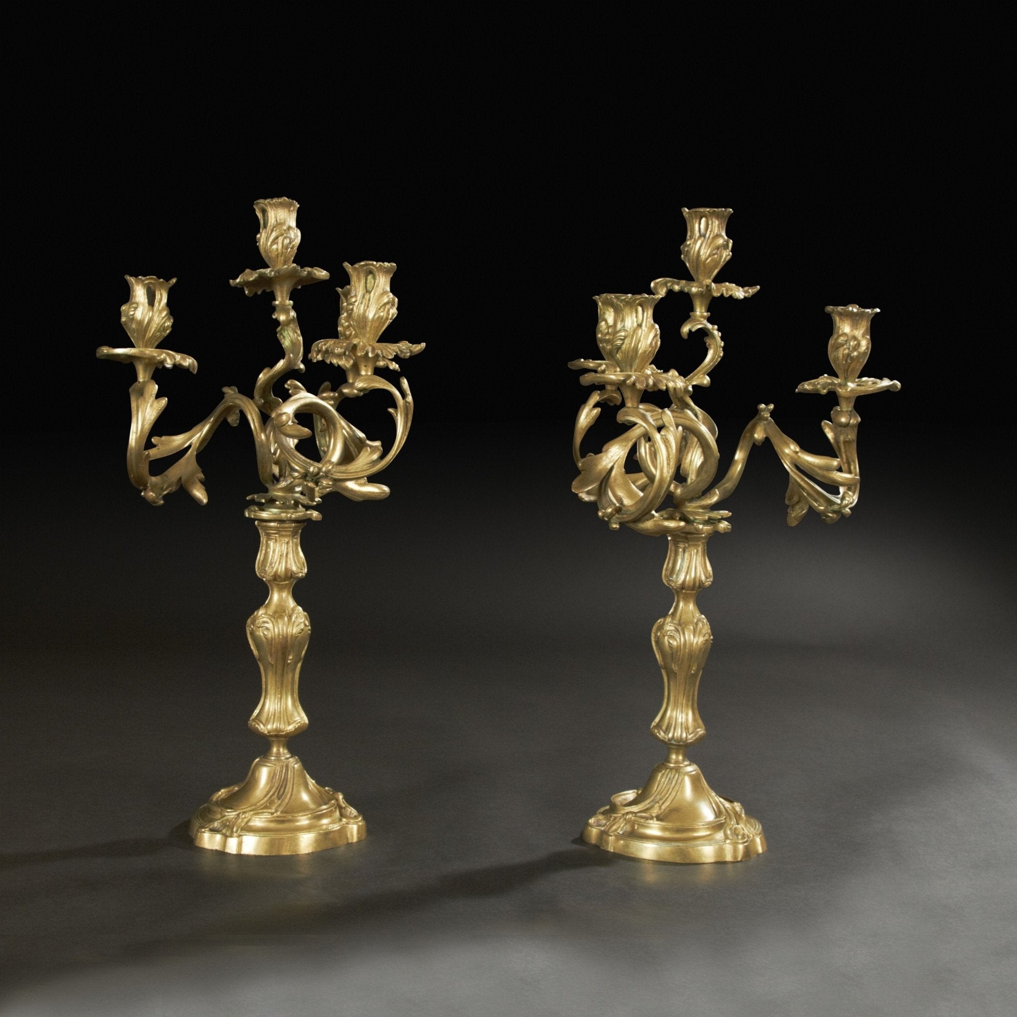 Elegant bronze candelabra, dark background, detailed view.