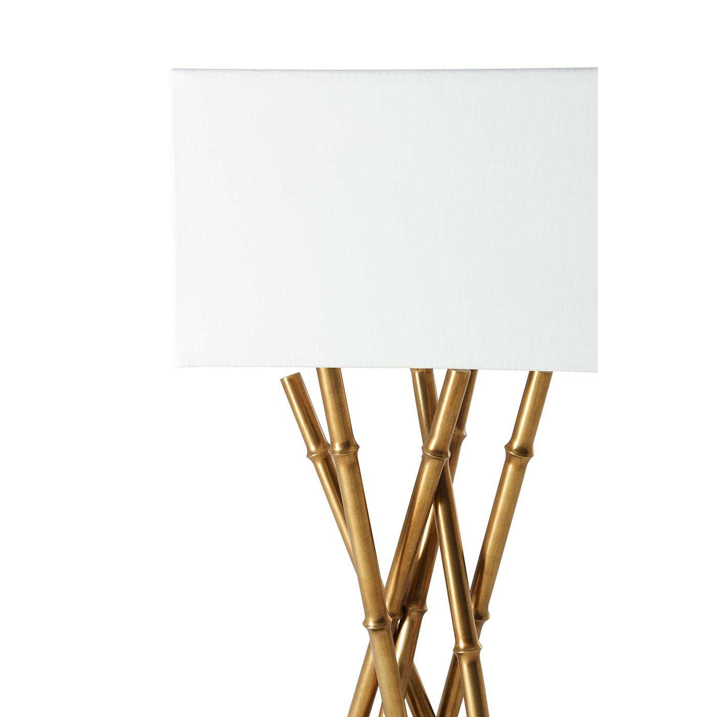 White-shaded table lamp highlighting brass bamboo-style design.