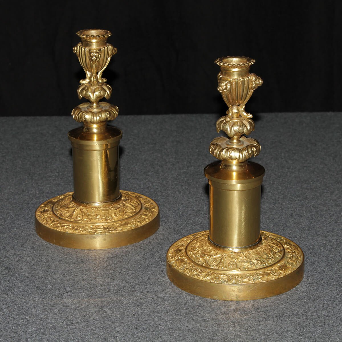 Side view of Neo Classic candlesticks on gray surface.