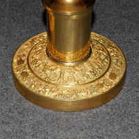 Close-up of candlestick base with floral engravings.
