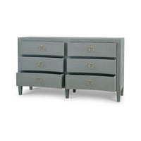 Pale blue dresser, open drawers, gold handles.