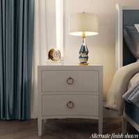 Styled nightstand in bedroom, lamp and clock on top.