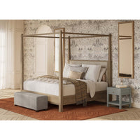 Bedroom setting with nightstand beside canopy bed.