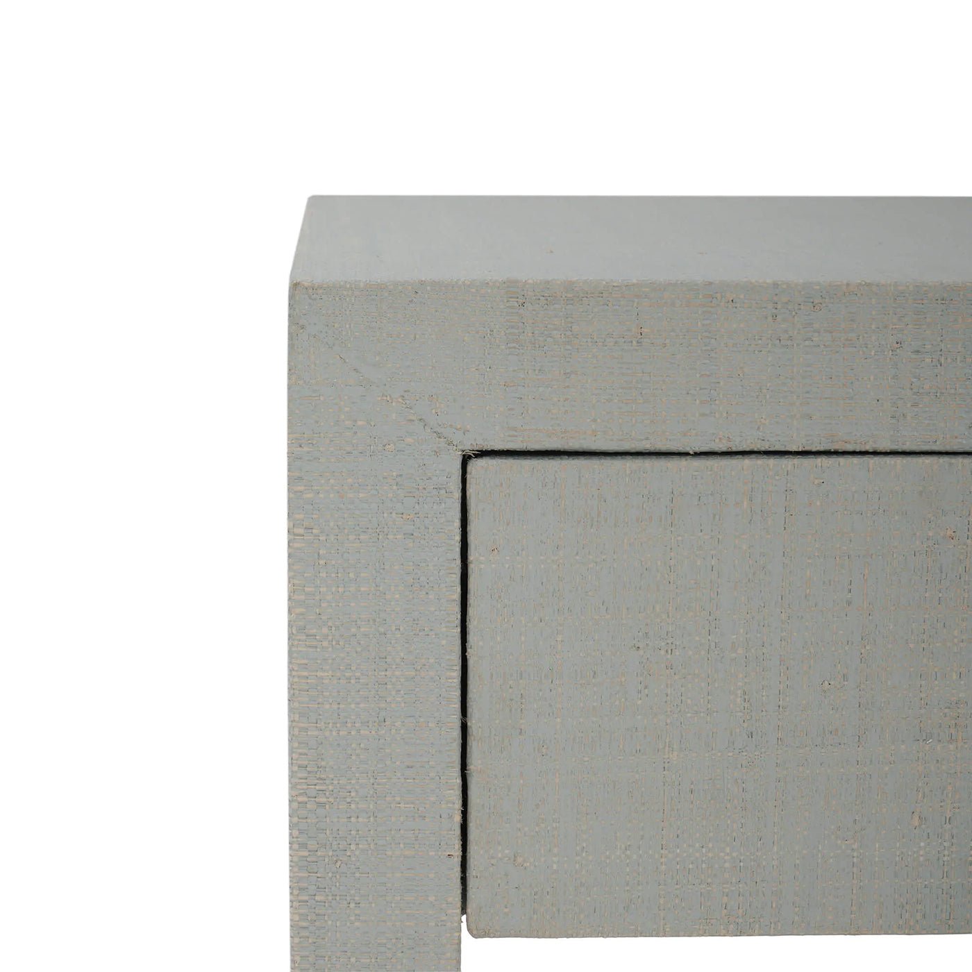 Close-up of raffia texture on nightstand corner.