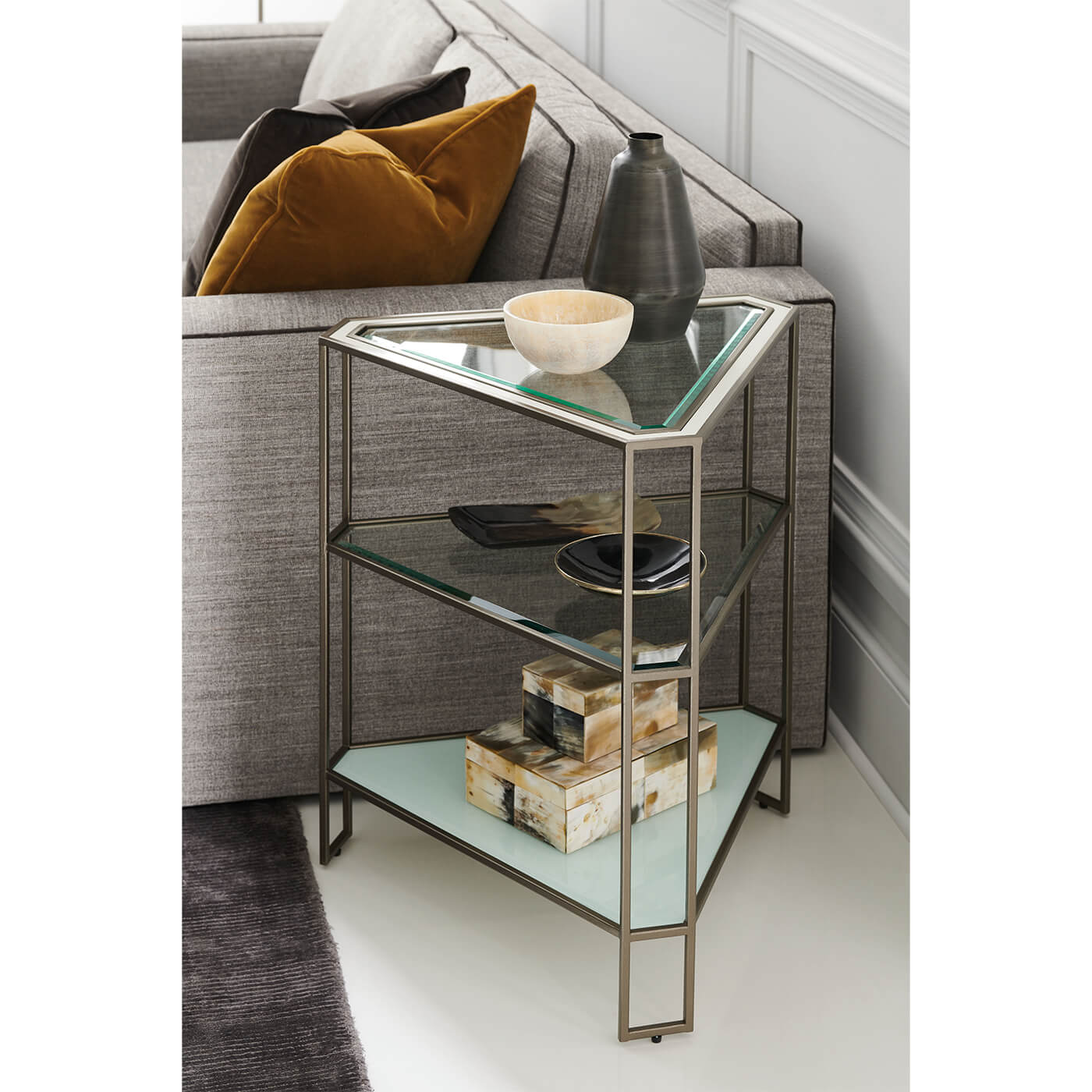 Corner of sofa with decorative glass side table.
