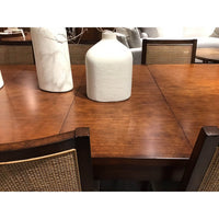 Close-up, extended Parsons table, mahogany top with decor.