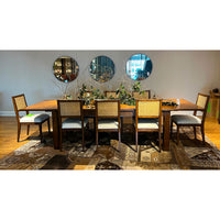 Extended Parsons table with chairs, dining setup, mirrors behind.