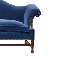 Close-up of blue camelback sofa arm and cushion.