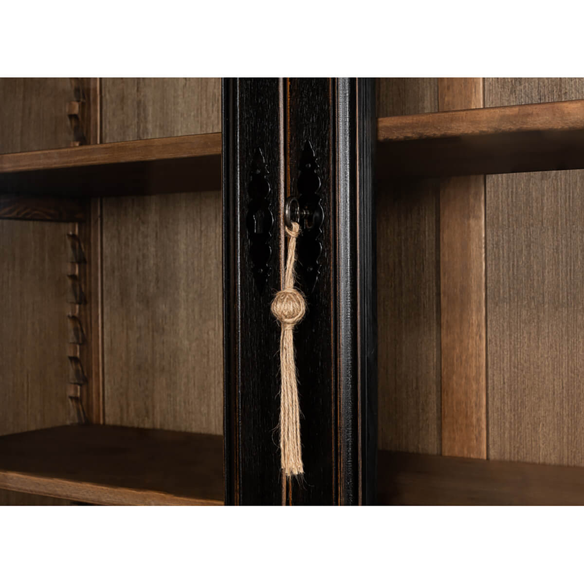 Center tassel detail on ebonized display cabinet door.