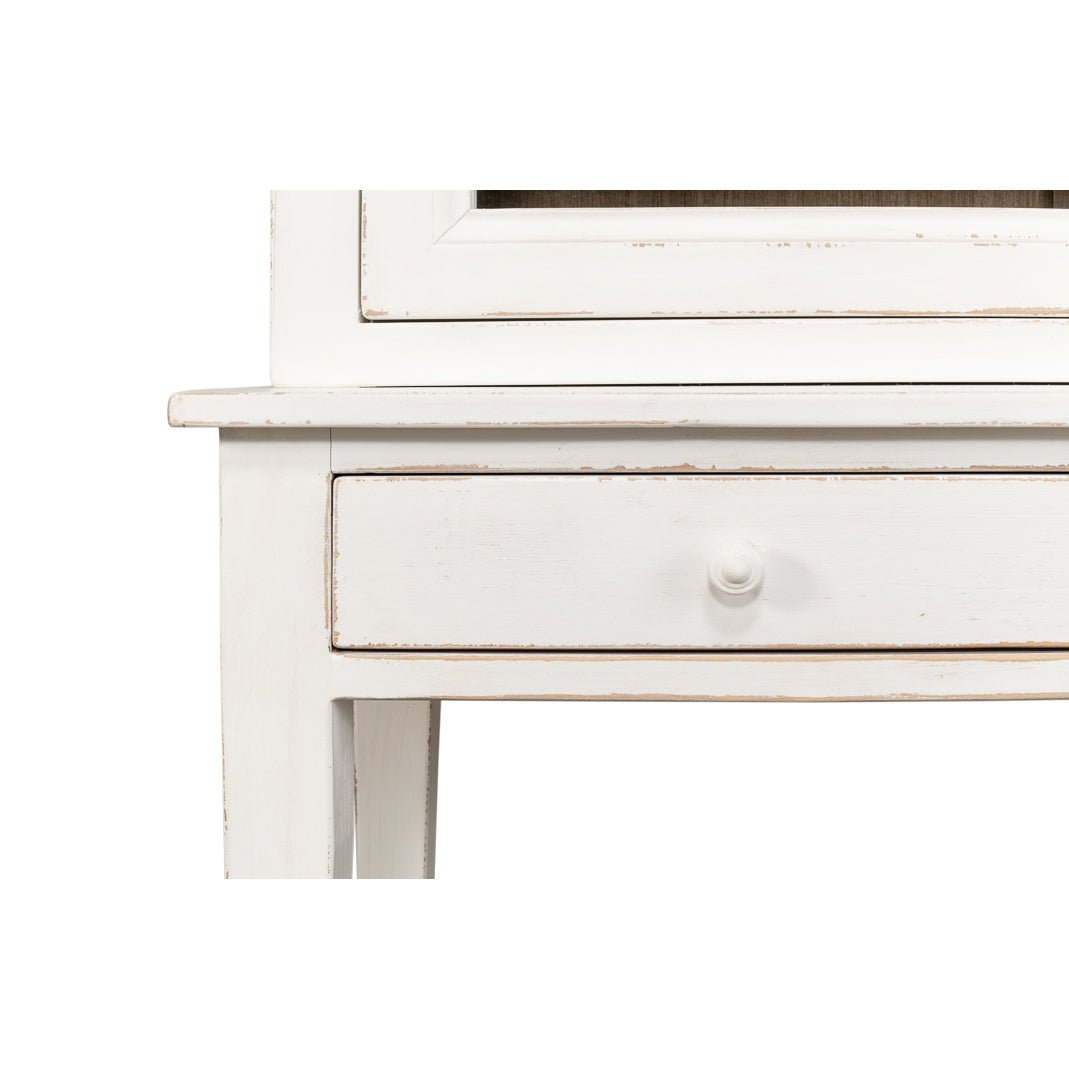 Close-up of drawer handle on white display cabinet.
