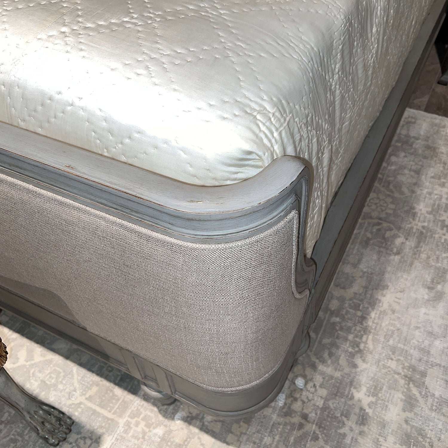 Side view of bed footboard with fabric and wood.