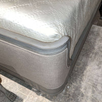 Side view of bed footboard with fabric and wood.