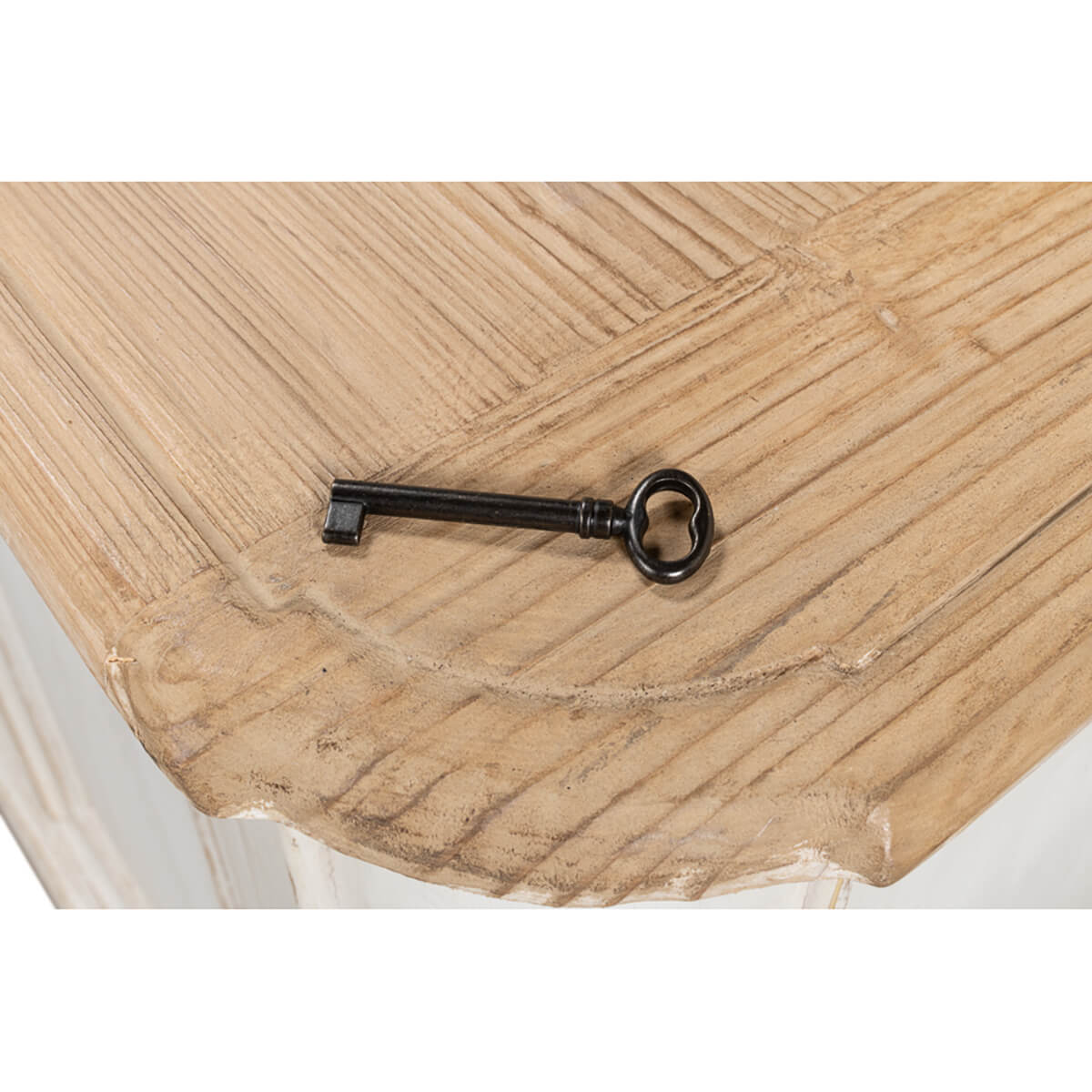 Antique key on wooden top of painted buffet.