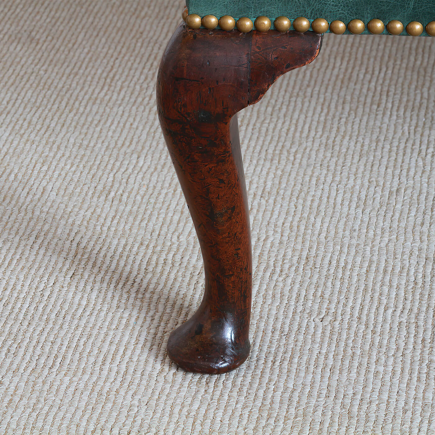 Detailed view of wingchair leg with cabriole design.