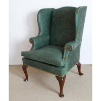 Wingchair angled view, leather upholstery, and decorative studs.