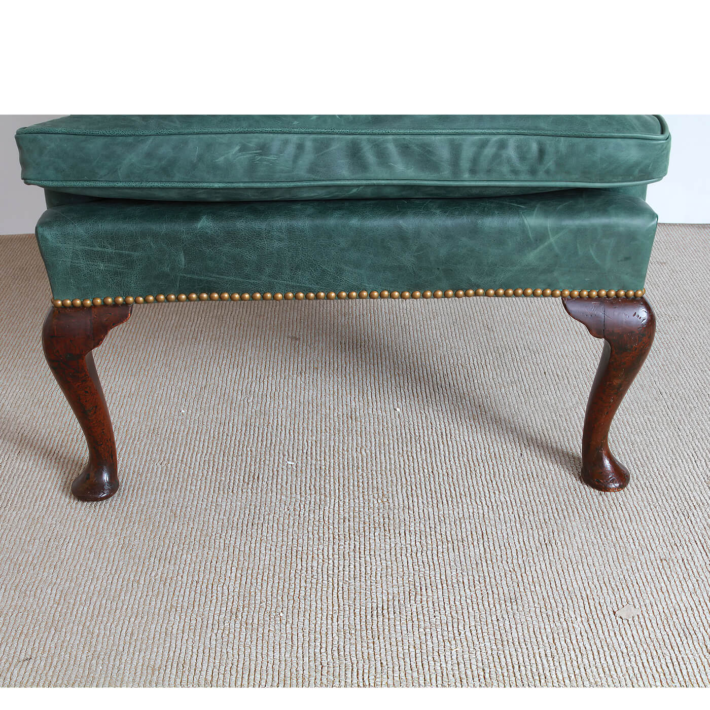 Close-up of wingchair seat cushion and wooden legs.