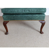 Close-up of wingchair seat cushion and wooden legs.