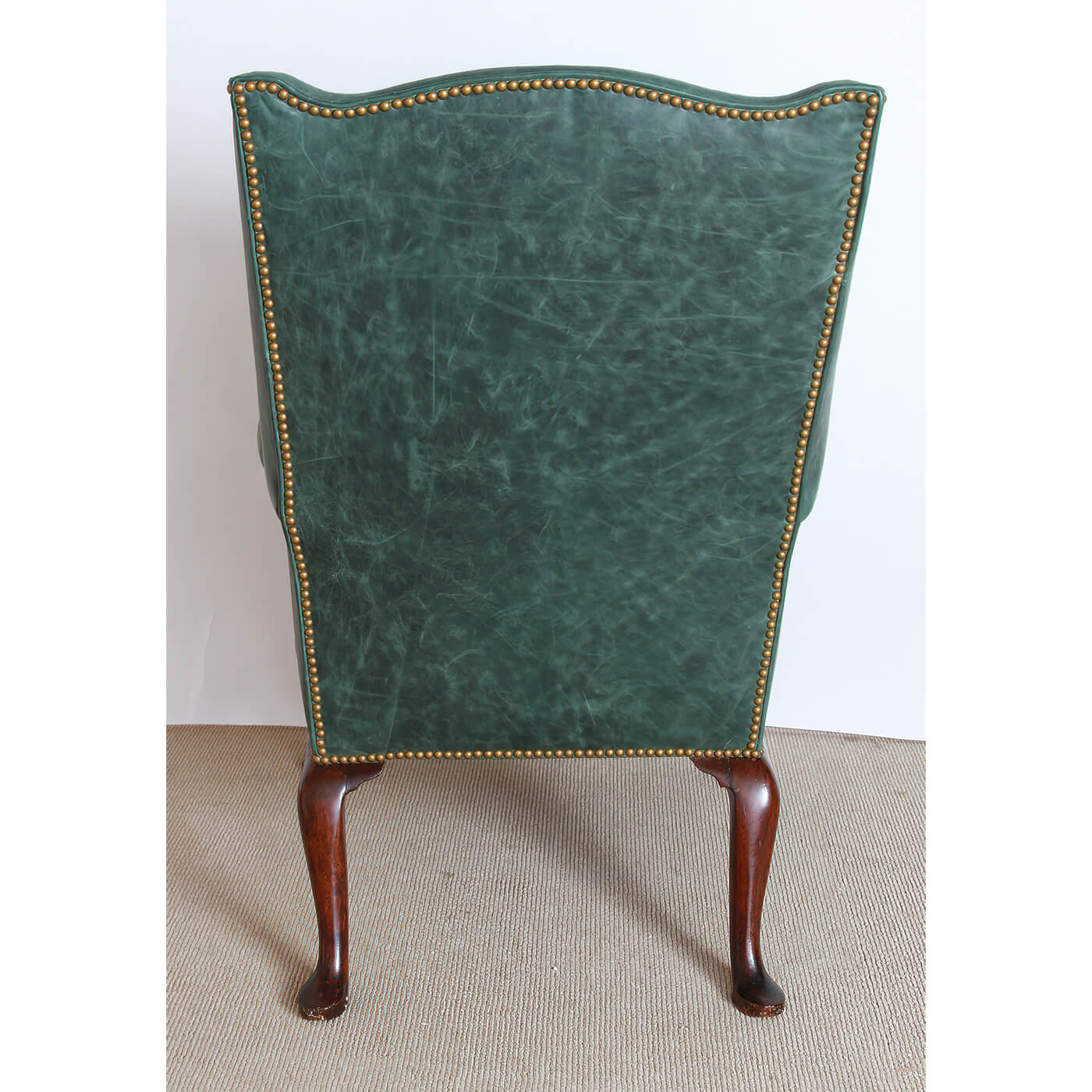 Back view of the green leather upholstered wingchair.